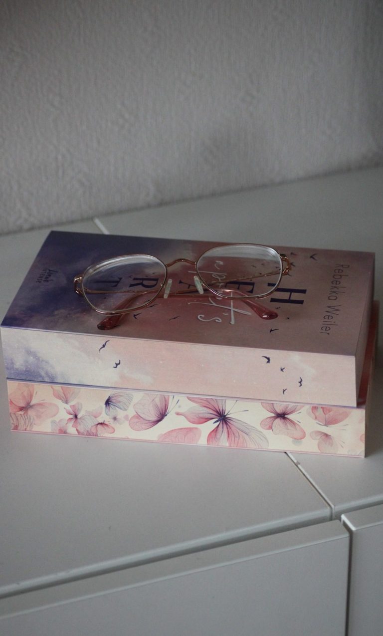 Eine dekorative Schachtel mit Blumenmuster und einer transparenten Brille darauf.