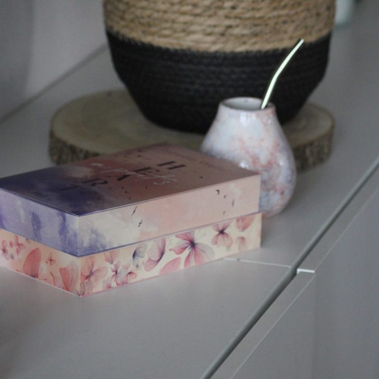 Bunte Box und eine kleine, gefächerte Vase auf einer hellen Oberfläche.