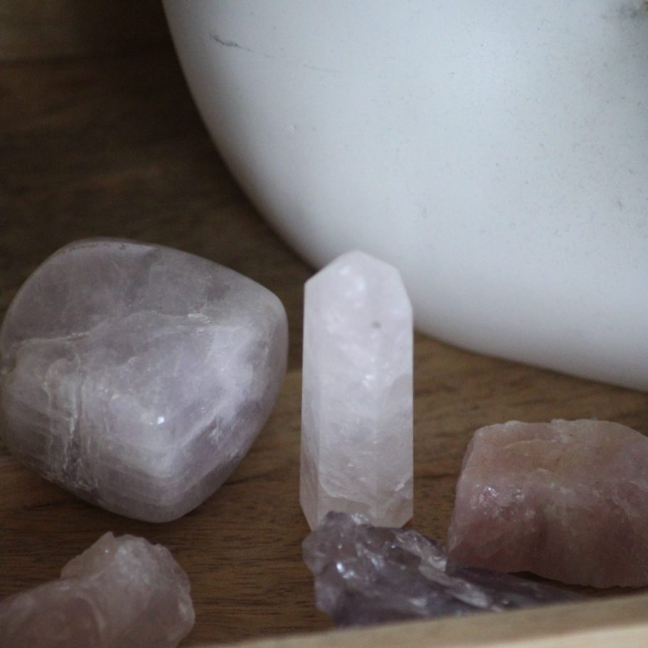 Mehrere Kristalle in unterschiedlichen Formen und Farben auf einer Holzoberfläche.